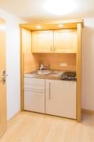 a kitchen with white cabinets and a sink at Das kleine, feine SONNWEND in Alpbach