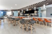 a restaurant with tables and chairs and a bar at Holiday Inn & Suites Cedar Falls-Waterloo Event Ctr by IHG in Cedar Falls