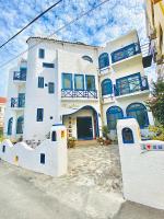 a large white building with blue windows at Morpheus B&amp;B in Kenting