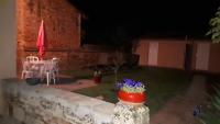 a patio at night with a table and chairs at Auberge des chemins in Moissac