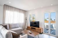Una sala de estar con un sofá y un televisor. en Thira Gold Suites, en Fira