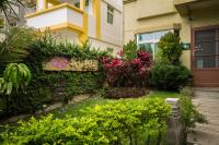 a garden in front of a house with flowers at Be my house in Magong