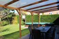 a wooden pergola with a table and chairs on a deck at Maison du Lavoir Disneyland in Bailly-Romainvilliers