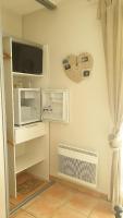 a room with a wall with a fan and a tv at La Villa d&#39;Olivène in Cuers