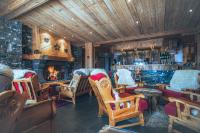 a bar with rocking chairs and a fireplace at Hôtel Le Sherpa Val Thorens in Val Thorens