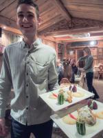 a man is holding two plates of food at Hôtel Le Sherpa Val Thorens in Val Thorens
