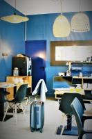 a blue room with chairs and a table and a suitcase at Hôtel Jules in Le Touquet-Paris-Plage