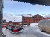 a person laying in a hammock on a roof at Hôtel Le Sherpa Val Thorens in Val Thorens