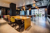 Un comedor con una gran mesa y sillas de madera. en Hotel Nodo - El hotel que respira, en Santiago