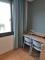 a room with a table and two chairs and a window at Light Blue Hostel in Hengchun South Gate