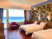 a hotel room with two beds and a large window at 36 Lighthouse in Hualien City