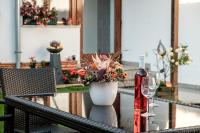 einen Tisch mit einer Vase aus Blumen und einem Weinglas in der Unterkunft Gästehaus Ranftl in Unterlamm