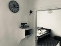 Zimmer mit einer Uhr an der Wand und einem Bett in der Unterkunft Kokos Traditional Family House in Kap Sounion