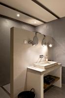 a bathroom with a sink and two lights on the wall at Bassiviere Barn Chic in Saint-Étienne-de-Villeréal