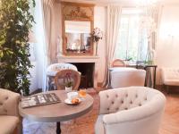 a living room with a table and chairs and a fireplace at Hotel Villa Catarie in Guéthary