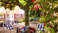 an outdoor patio with tables and chairs and flowers at Hotel Villa Catarie in Guéthary