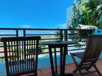 a table and chairs on a balcony with a view of the ocean at Ibali Hostel in Magong