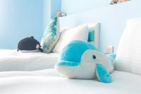 a stuffed dolphin is sitting on a bed at Ciao Life B&amp;B in Taitung City