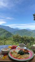 a plate of food on a table with mountains in the background at Margaret Garden Villa in Ren&#39;ai