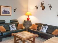 a living room with couches and antlers on the wall at Perfect spot on the edge of a large wood in Awenne