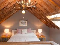 a bedroom with a large bed with two lamps at Perfect spot on the edge of a large wood in Awenne