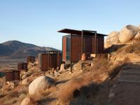 a building on the side of a hill with rocks at Encuentro Guadalupe in Valle de Guadalupe