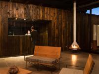 a man in a suit standing in a room with a woman at Encuentro Guadalupe in Valle de Guadalupe