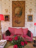 a living room with a pink couch and roses at Chateau de Hiéville in Hiéville