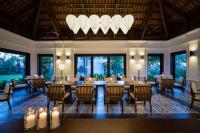 金兰The Anam Cam Ranh的餐厅里有桌椅和吊灯