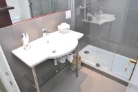 a bathroom with a white sink and a shower at Hôtel Le Beaufort in Saint Malo