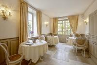 a dining room with tables and chairs and windows at Hotel Villa Catarie in Guéthary