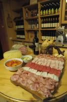 ein Tisch mit Fleisch und anderen Speisen sowie Flaschen Wein in der Unterkunft Agriturismo Sol De Montalto in Rivoli Veronese