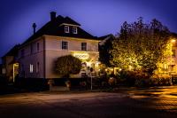 un edificio con un cartel en su costado por la noche en Gasthaus &amp; Hotel Bischoff, en Rodgau