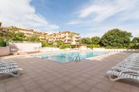 a swimming pool with lounge chairs and a building at Résidence Pierre &amp; Vacances Eden Parc in Saint-Tropez