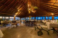 Un restaurante con mesas y sillas y una lámpara de araña. en Arraial D'ajuda Eco Resort, en Arraial d'Ajuda
