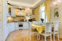Una cocina con gabinetes blancos y una mesa y sillas. en Apartmán Nostalgia, en Karlovy Vary