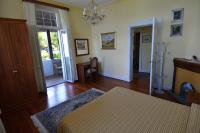 a bedroom with a bed and a chandelier at Hotel Villa Ruscello in Baveno