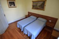 a bedroom with two beds and a picture on the wall at Hotel Villa Ruscello in Baveno