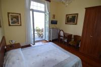 a bedroom with a large bed and a balcony at Hotel Villa Ruscello in Baveno