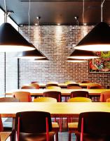 a dining room with tables and chairs and lights at citizenM New York Times Square in New York