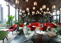 a lobby with colorful chairs and tables and plants at citizenM New York Times Square in New York