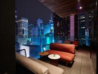 a room with a couch and tables and a city skyline at citizenM New York Times Square in New York