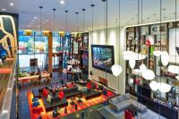 an overhead view of a living room with tables and chairs at citizenM New York Times Square in New York