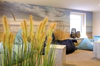 a living room with a couch and some tall grass at WIROtel Warnemünde in Warnemünde