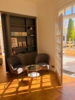 ein Wohnzimmer mit zwei Stühlen und einem Glastisch in der Unterkunft Villa Agrippa in Orange