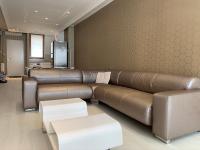 a living room with a large brown leather couch at Ruben Apartman City Center in Debrecen