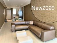 a living room with a brown leather couch and a sign at Ruben Apartman City Center in Debrecen