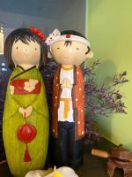 two figurines of two people standing next to a bed at Redbean Guesthouse in Wujie