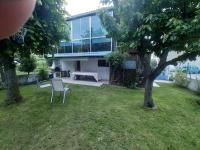 a house with a table and chairs in a yard at Chalet dans village in Saint-Maurice-en-Trièves