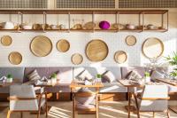 un restaurante con mesas, sillas y cestas en la pared en Fusion Resort Cam Ranh - All Spa Inclusive, en Cam Ranh